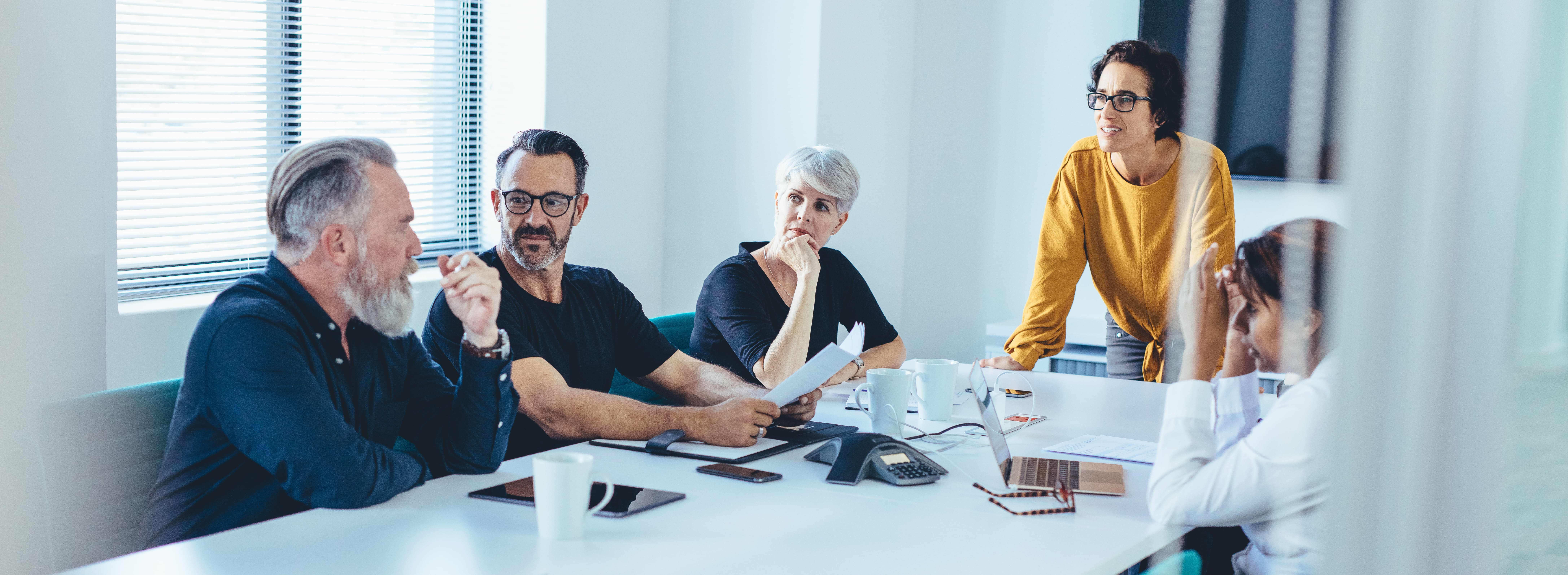 Group of business people having team meeting in a board room. Senior businessman putting his ideas forwards during meeting in conference room.