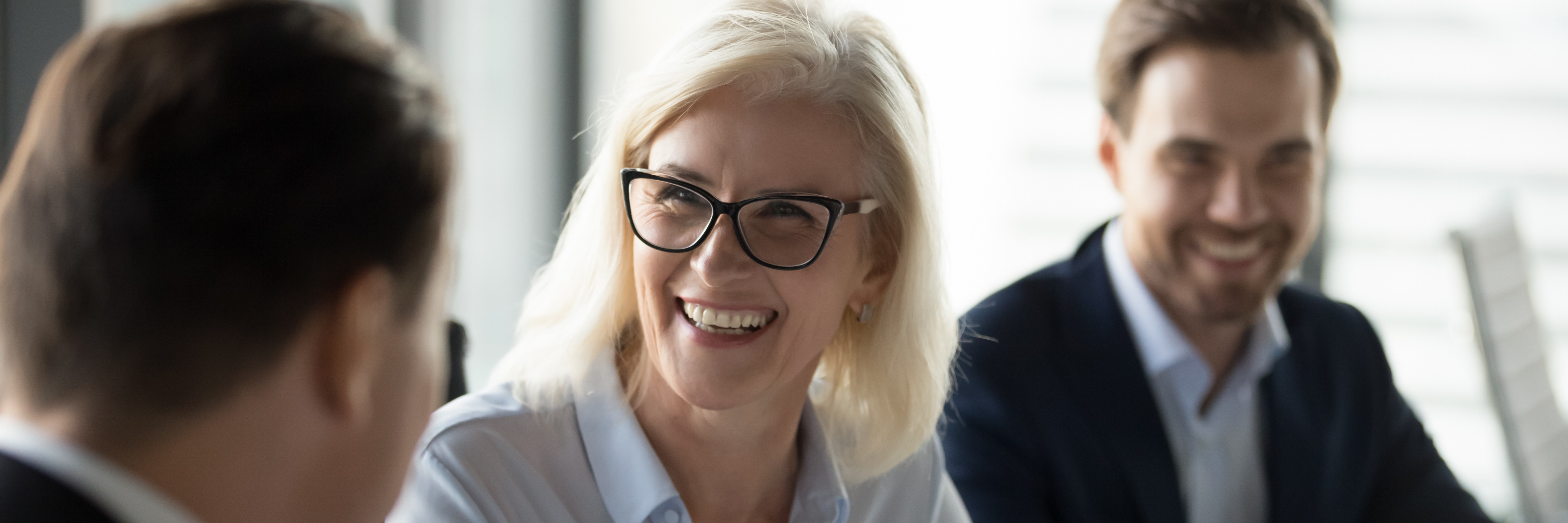 Mature businesswoman lead negotiations, during business meeting with company investor or client businesspeople laughing enjoy friendly talk concept. Horizontal photo banner for website header design