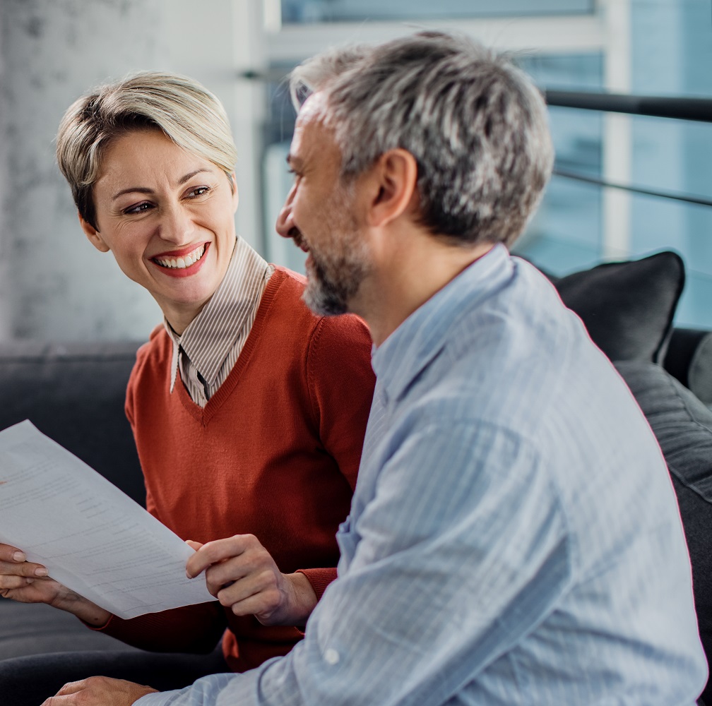 Happy mid adult couple having a meeting with financial advisor in the office. Focus is on woman. ; Shutterstock ID 1866776692; purchase_order: ; job: Generali Poland; client: Generali; other: 