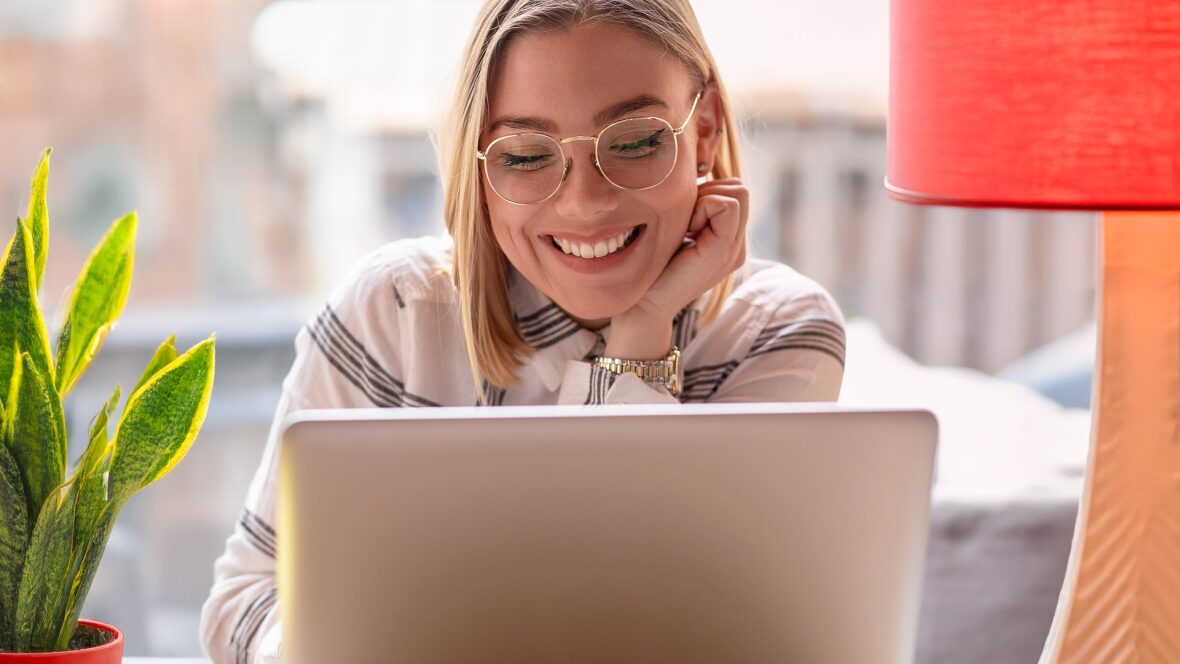 Persona joven usando apps de empleo desde el portátil en su casa.