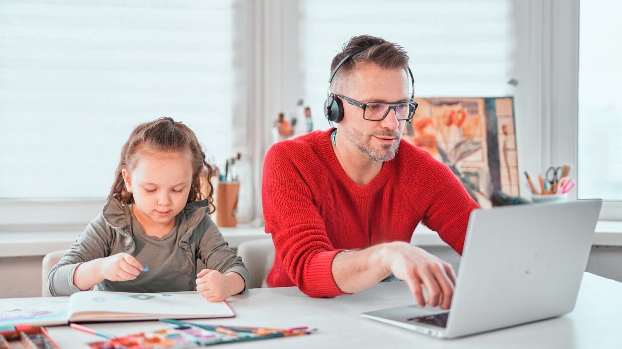 Persona teletrabajando en horario flexible y compartiendo tiempo con su hijo.